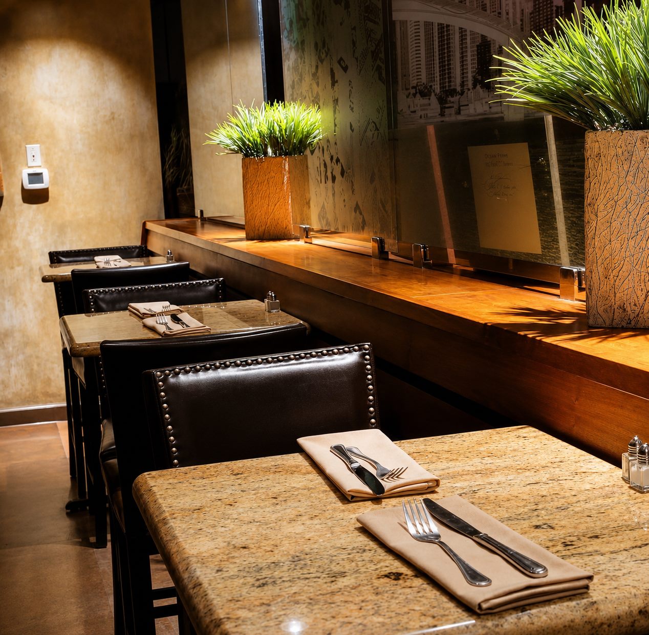 The warm dining room at Skylines, with etched glass skyline panels behind the bar