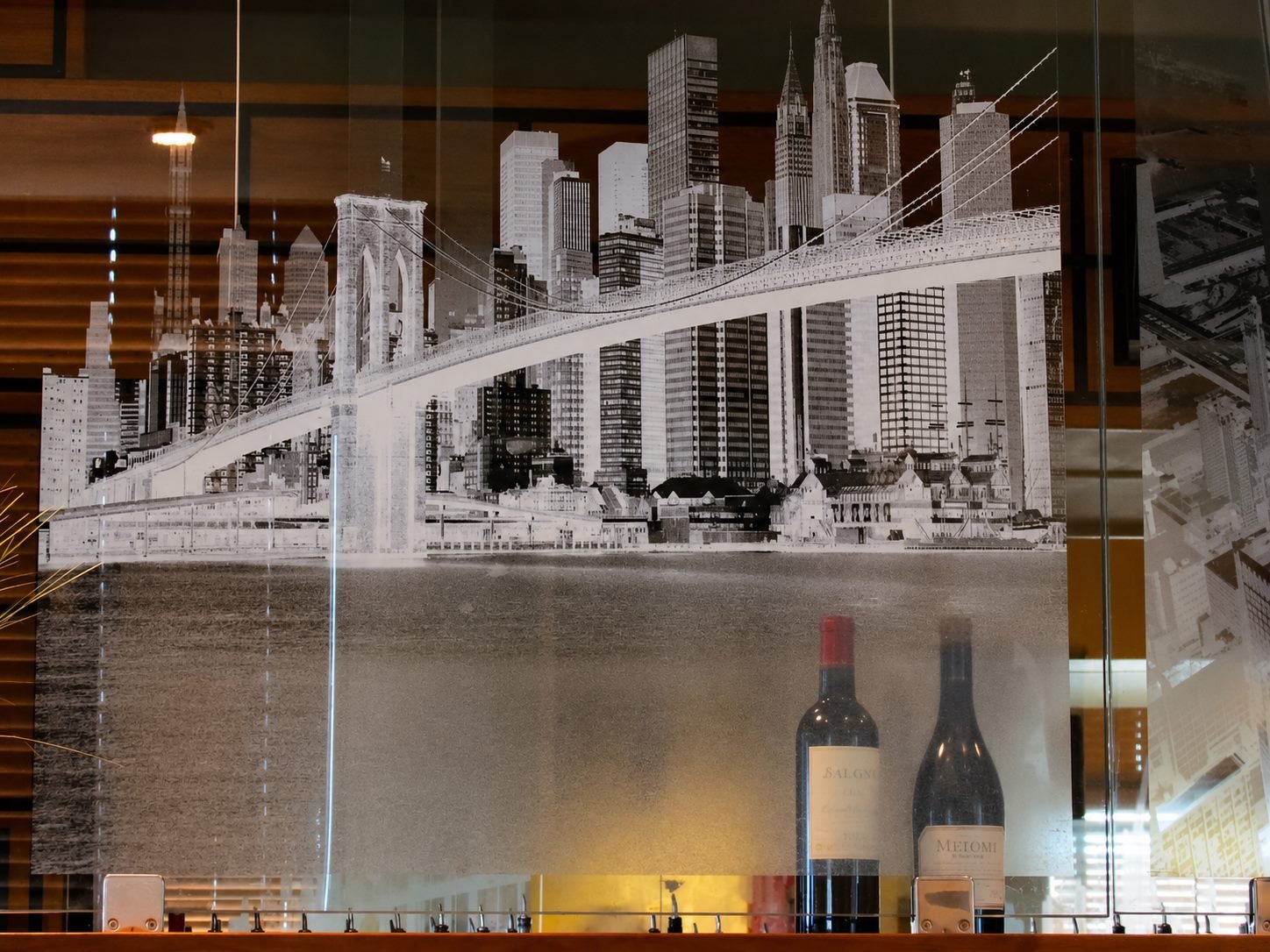 An etched glass panel depicting the New York City skyline and the Brooklyn Bridge